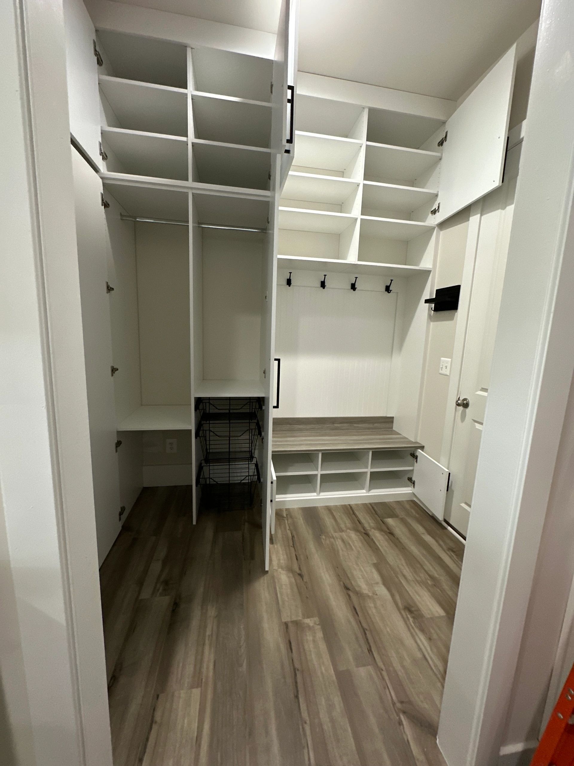 Spacious mudroom white shelves hooks storage baskets Fantasy Closets